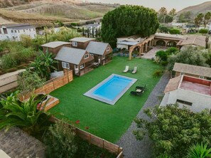 A residential area with a swimming pool, multiple houses, and a large tree. - Long Stay Cabin 1 - by Hacienda Cuatro Milpas (Ensenada)