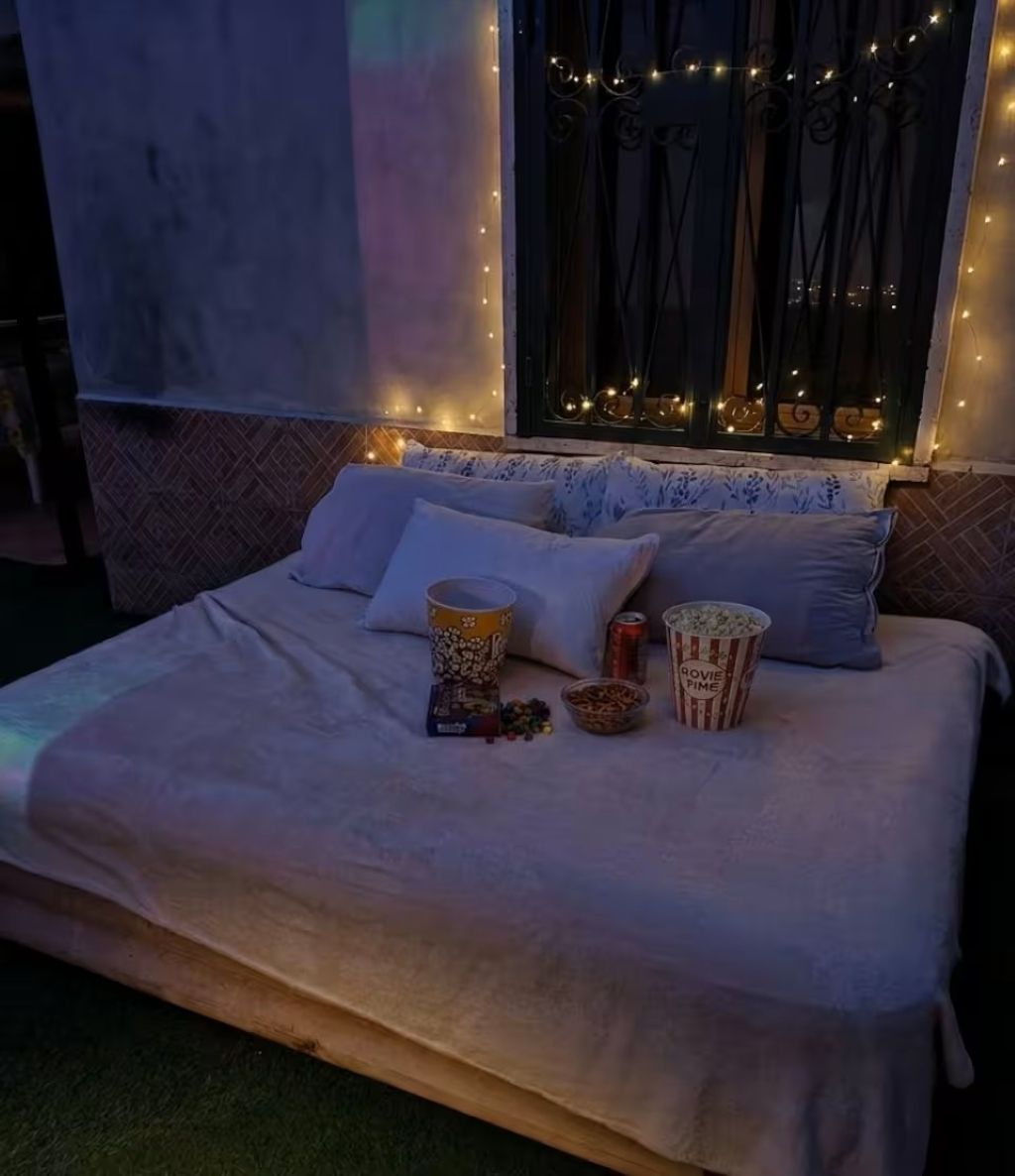 Ein Bett mit Kissen, einer Popcorndose und einer Limodose.