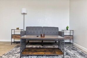 A modern living room with a grey sofa, a wooden coffee table, and two side tables with lamps. - Convenient Mesa Stay • Close to Everything (Mesa)