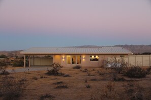 A single-story house with a flat roof, a garage, and a covered driveway. - Modern 2-bedroom house with Pool & Spa Joshua Tree (Joshua Tree)
