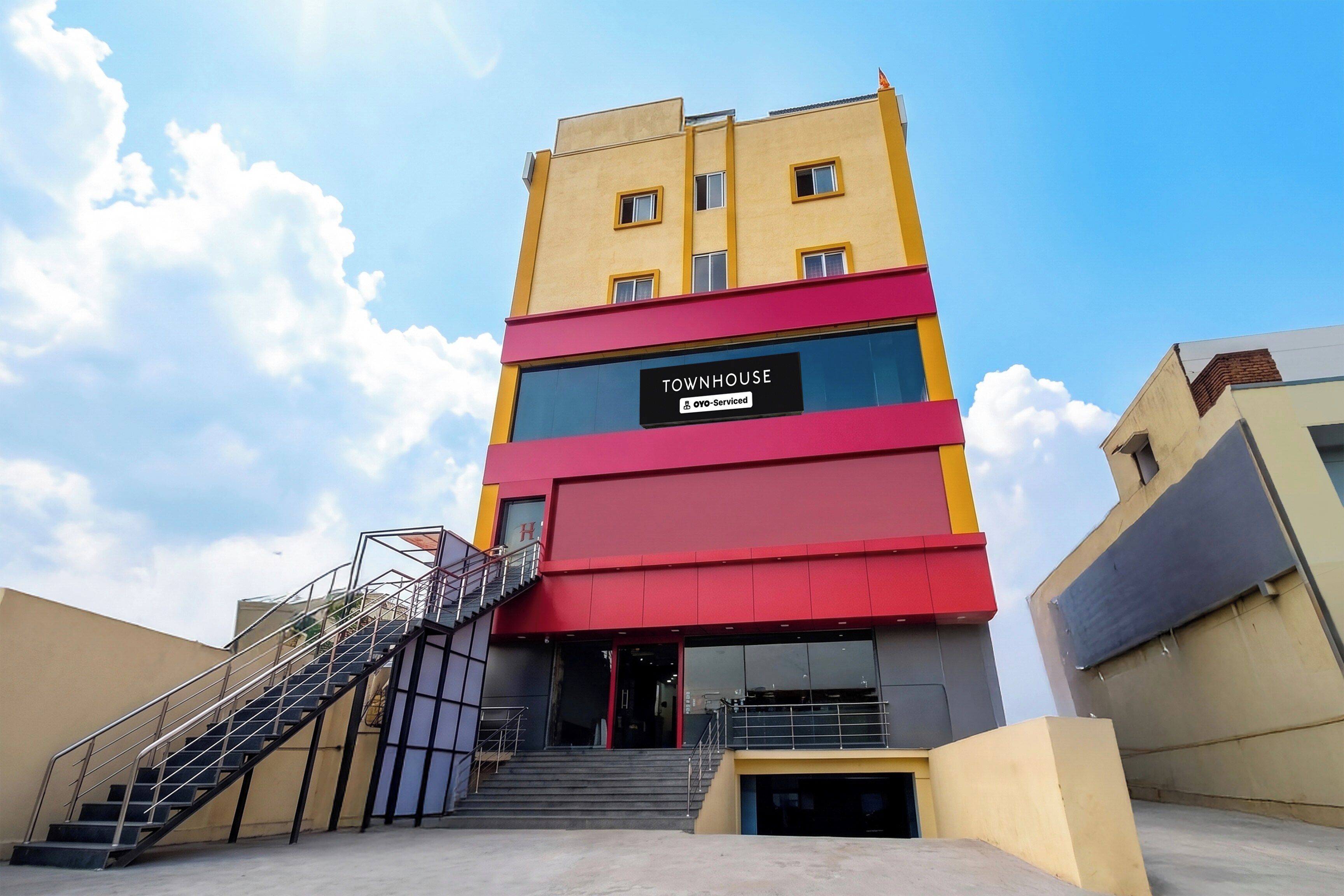 A multi-story building with a sign reading 'TOWNHOUSE' and 'OVO-Serviced'.