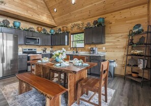 A wooden interior with a kitchen, dining table, and chairs. - What a Wonderful World * 2 bed * 3 bath * sleeps 6 (Sevierville)