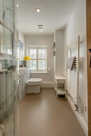 A bathroom with a toilet, a shower area, a glass-enclosed shower, and a towel rack. - 1 Bed in Snape (oc-sfmcs) (Snape)