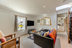 A living room with a sofa, a coffee table, a TV, and a window with curtains. - 1 Bed in Snape (oc-sfmcs) (Snape)