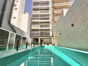 A swimming pool area with a view of a multi-story building in the background. - 25- Modern Space in Palermo Soho w/Pool (Buenos Aires)