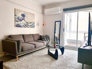 A modern living room with a sofa, a glass coffee table, and a large painting on the wall. - 28- Incredible Oriental Style Apt. /Palermo Soho (Buenos Aires)