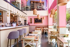 A café with a bar area, wooden tables, and hanging wicker lamps. - 28- Incredible Oriental Style Apt. /Palermo Soho (Buenos Aires)
