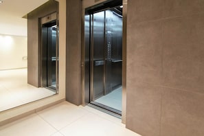 A modern elevator with a metallic finish, situated in a hallway with a tiled floor. - 201- Modern Apt. w/ Great Amenities in Palermo (Buenos Aires)