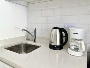 A kitchen with a stainless steel sink, a kettle, and a coffee maker. - 201- Modern Apt. w/ Great Amenities in Palermo (Buenos Aires)