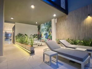 A modern outdoor lounge area with seating, plants, and a mural on the wall. - 24- Modern Space in Palermo w/ Pool 2 Beds. (Buenos Aires)