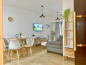 A modern living room with a dining area, a sofa, and a TV mounted on the wall. - 24- Modern Space in Palermo w/ Pool 2 Beds. (Buenos Aires)