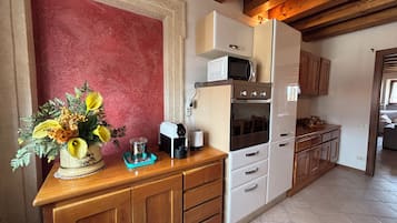 Una cocina con armarios de madera, un microondas, un horno y una cafetera.