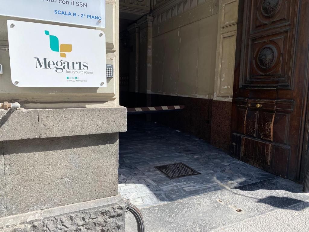 A Megaris luxury suite room entrance with a stone floor and a wooden door.