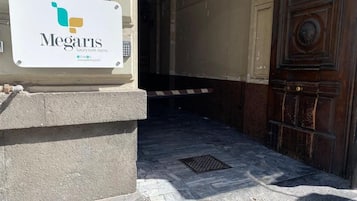 A Megaris luxury suite room entrance with a stone floor and a wooden door.