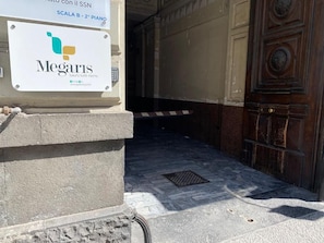 Entrada a una lujosa suite Megaris, con piso de piedra y puerta de madera.