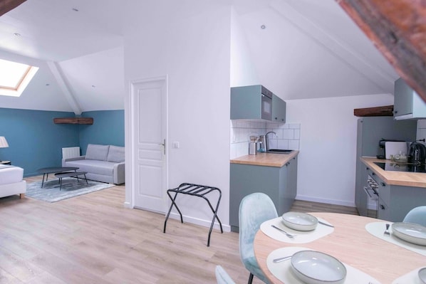A compact living space with a dining area, kitchenette, and a small seating area with a sofa and coffee table. - New Listing (Choisy-le-Roi)