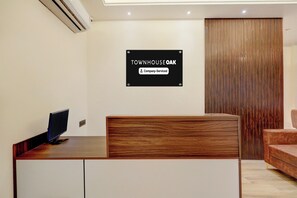 A reception desk with a sign indicating 'TOWNHOUSE OAK Company Serviced'. - Townhouse Oak Airport Ranchi (Ranchi)