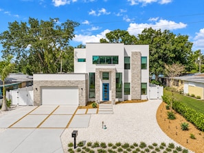 A modern two-story house with a garage, a driveway, and a well-maintained lawn. - Sarasota Coastal Retreat (Sarasota)