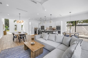 A modern living space with a dining area, a sofa, and a kitchen. - Sarasota Coastal Retreat (Sarasota)