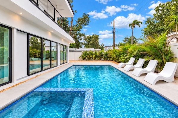 Resort-style private pool with tropical landscaping and sleek loungers