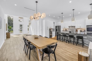 A modern kitchen with a central island, stainless steel appliances, and pendant lighting. - Sarasota Coastal Retreat (Sarasota)