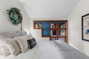 A bedroom with a bed, a window, and a wall-mounted plant. - Beautiful apartment on the river, near shops and close to major skiing resorts. (Frisco)