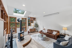 A modern living room with a fireplace, a sofa, a coffee table, and a desk. - Beautiful apartment on the river, near shops and close to major skiing resorts. (Frisco)