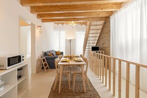 Ein modernes Interieur mit Essbereich, einer Couch, einer Treppe und einer Küchenzeile.