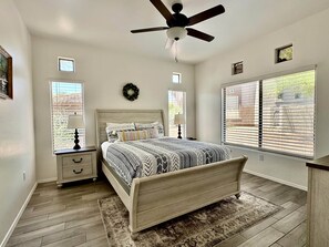 A bedroom with a bed, a nightstand, a ceiling fan, and a window with blinds. - Vistoso Resort Condo #107A (Oro Valley)