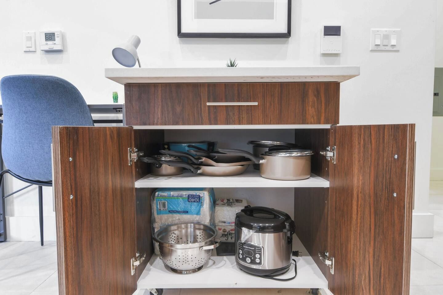 A kitchen with wooden cabinets, a coffee maker, and various pots and pans.