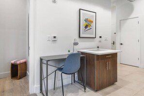 A modern office space with a desk, chair, and a cabinet. - 1BR 20 Min Manhattan 2 min prud center. Concerts! (Newark)