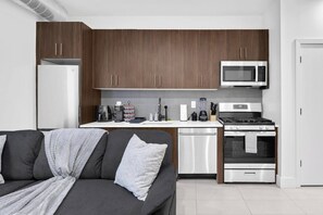 Una cocina compacta con microondas, estufa y lavavajillas.
