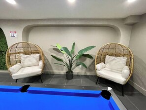 A pool area with two wicker chairs and a potted plant. - 1BR Oasis, 20 Min NYC, 4 Min to Prudential Concert (Newark)