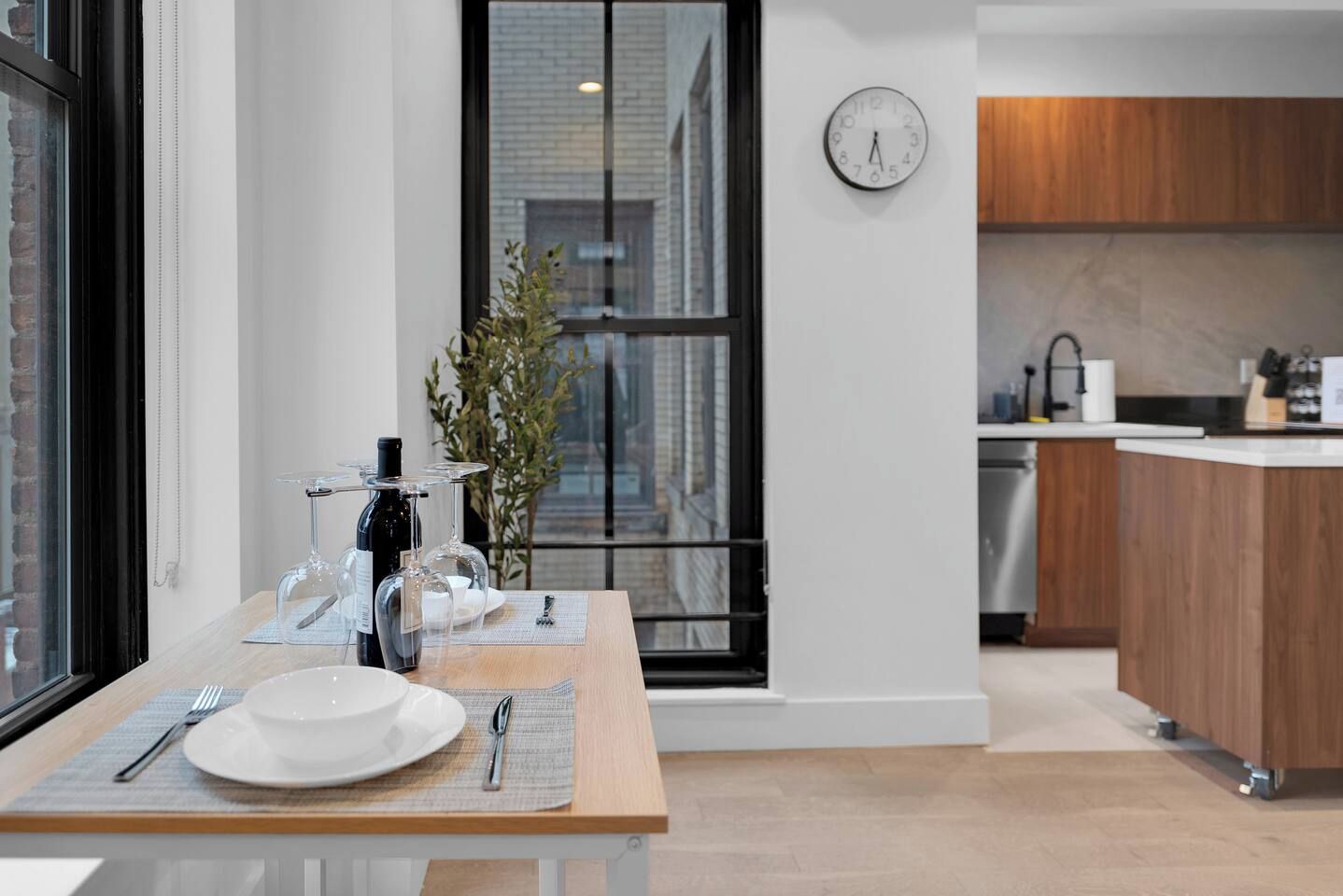 A modern kitchen with a wooden countertop, a sink, and a clock on the wall.