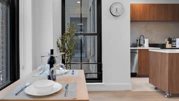 A modern kitchen with a wooden countertop, a sink, and a clock on the wall.