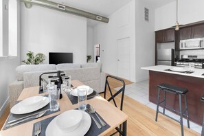 A modern apartment with a dining area, kitchen, and living space. - 2BR 20 min to NYC! Stylish Fun Cozy & Spotless (Newark)
