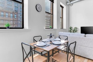 Un espacio moderno de estar con comedor, sofá y televisor.