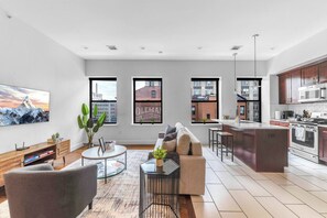 A modern apartment with a living room, kitchen, and dining area. - 20 MIN to Manhattan! 2BR Luxurious Comfy & Spotless (Newark)