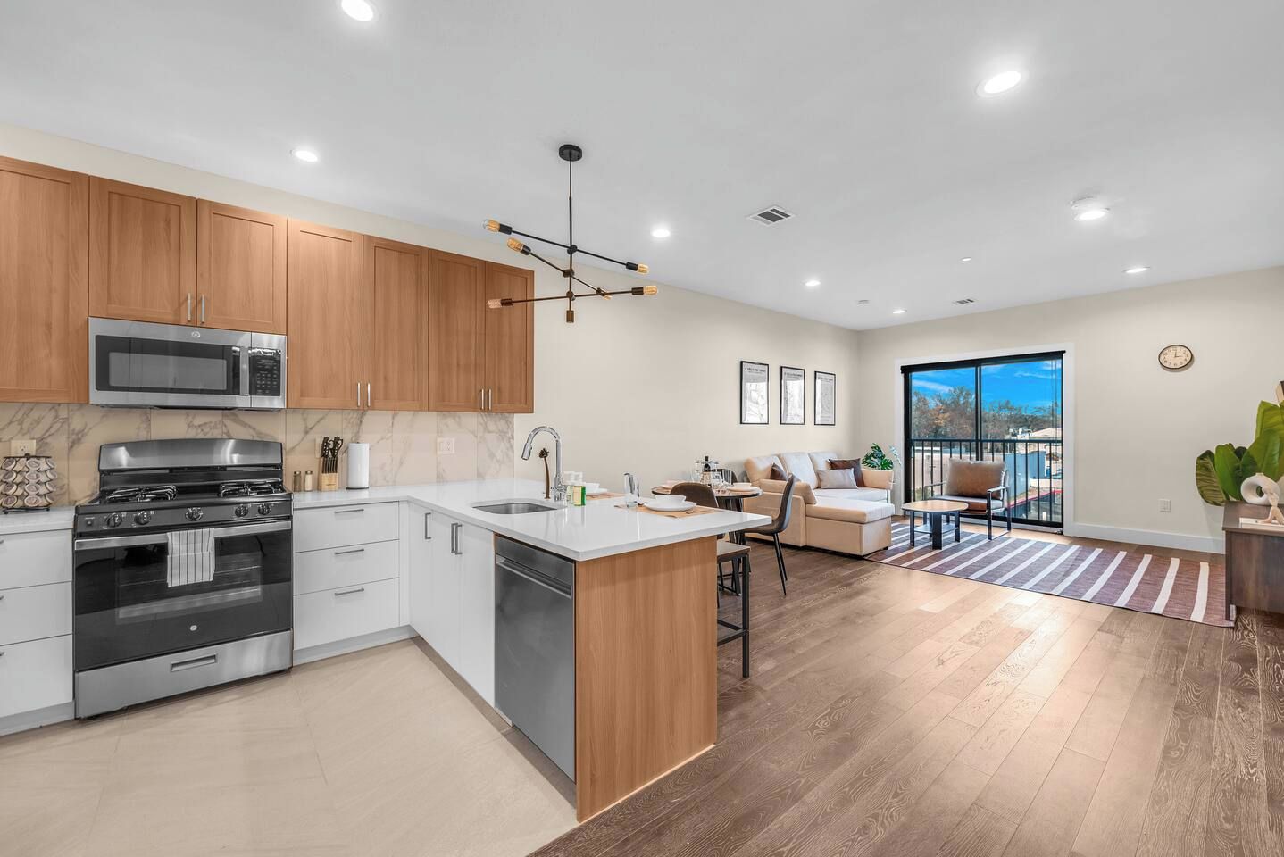 A modern kitchen with a central island, stainless steel appliances, and wooden cabinets.