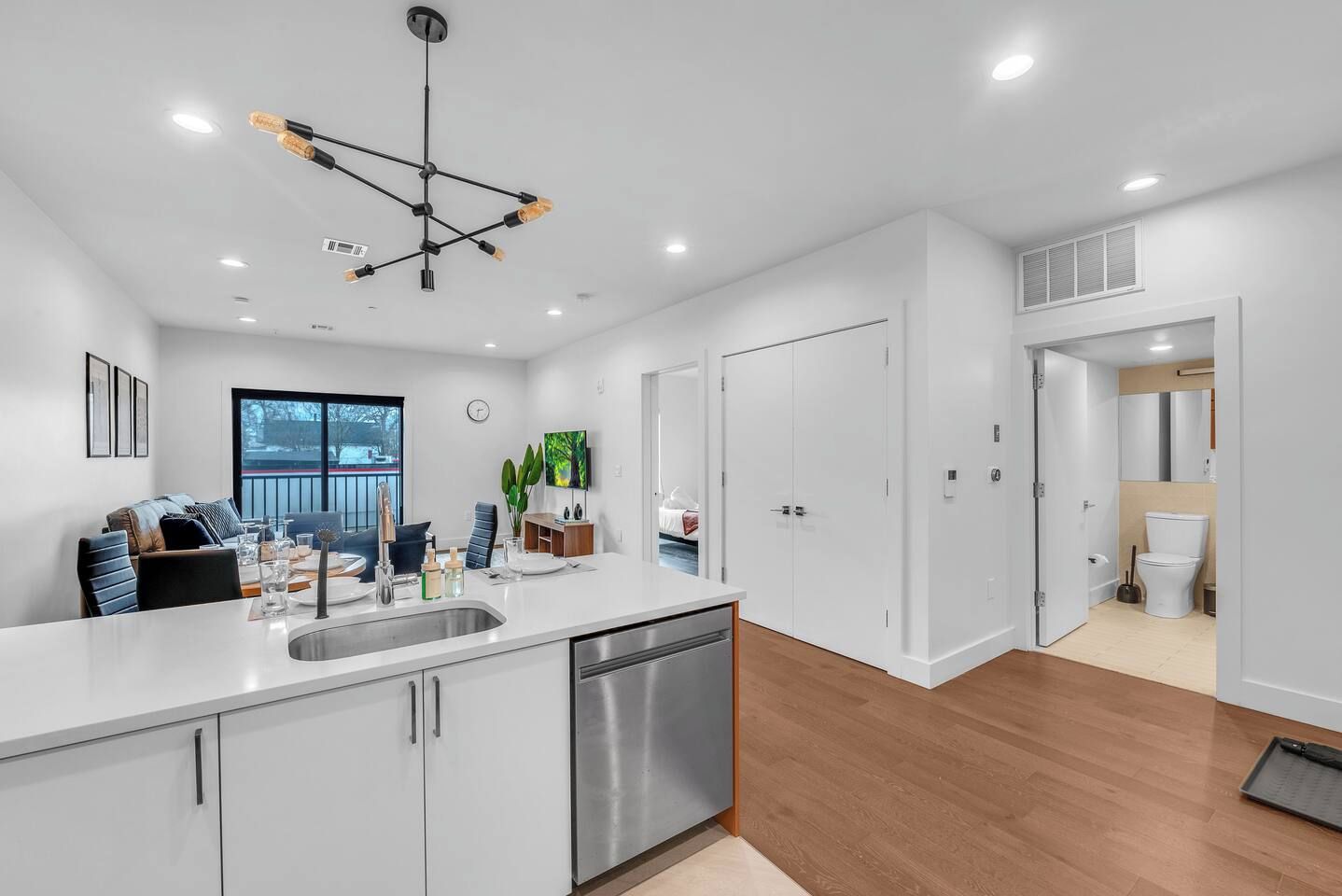 A modern kitchen with a central island, stainless steel appliances, and a pendant light fixture.