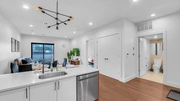 A modern kitchen with a central island, stainless steel appliances, and a pendant light fixture.