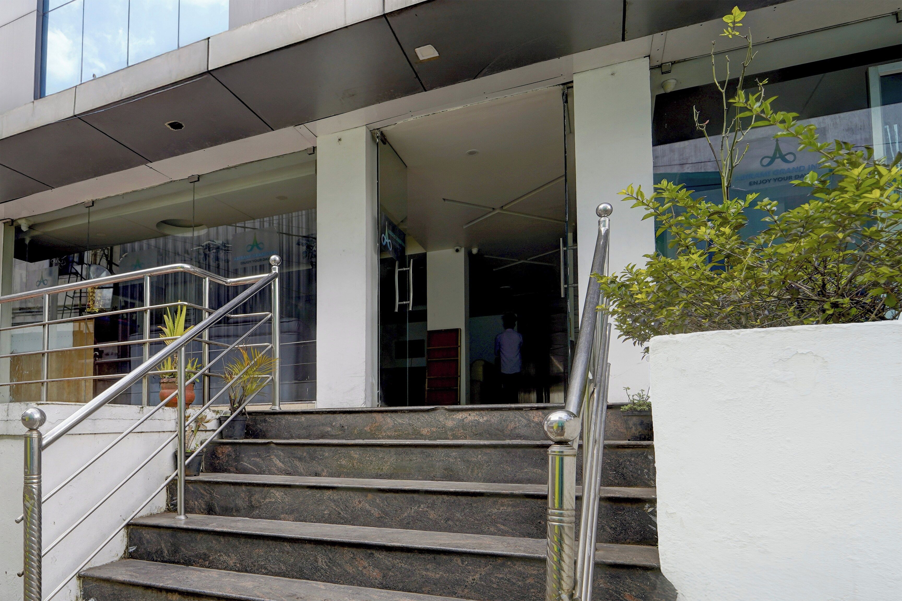 Una entrada de edificio con una escalera que lleva a una puerta.