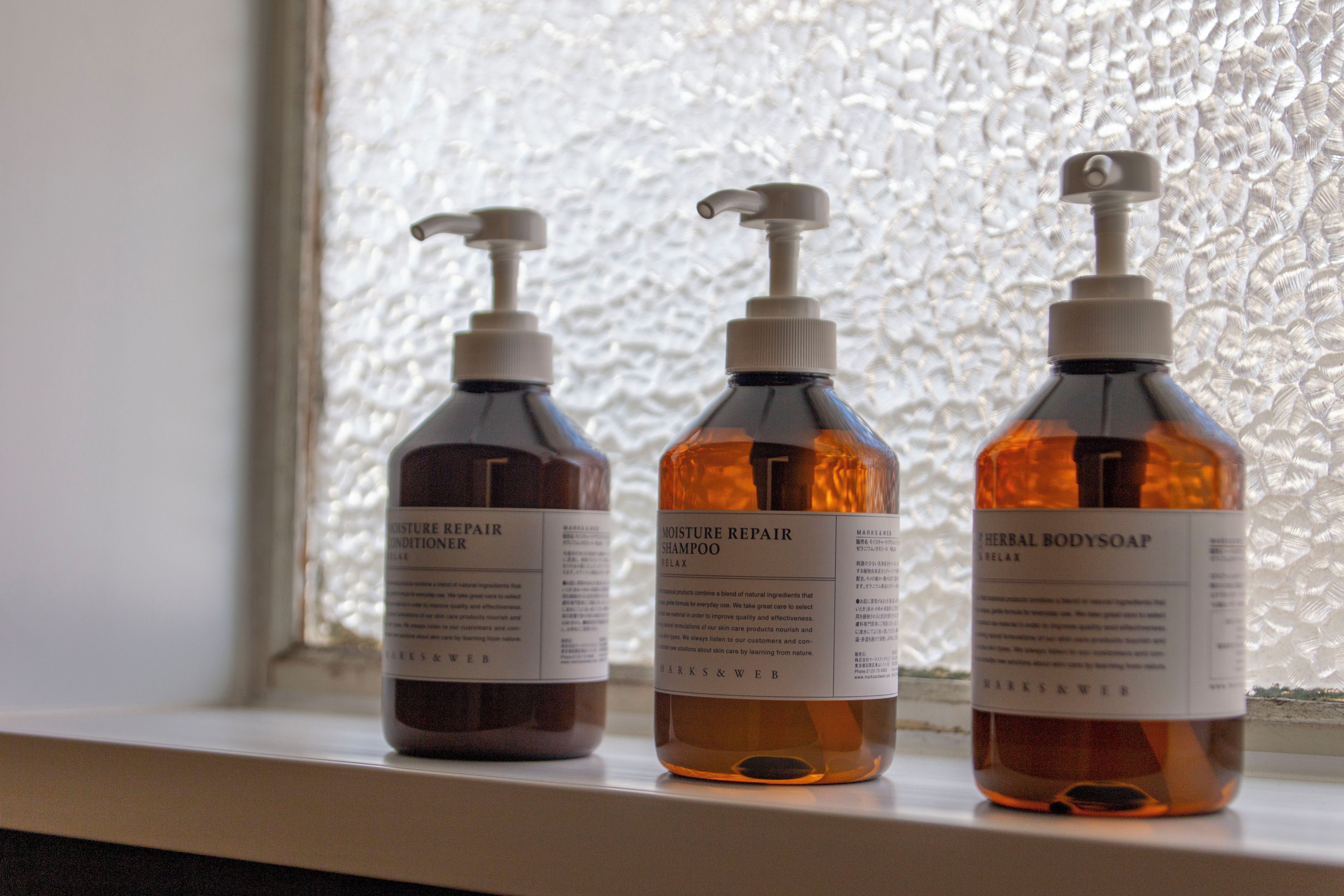 Three bottles of skincare products on a shelf.