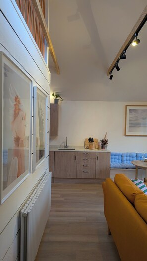 A modern kitchen with a built-in oven, a sink, and a countertop with a toaster and utensils. - Family stay near beach - Outdoor tub - Sleeps 6 (Bournemouth)