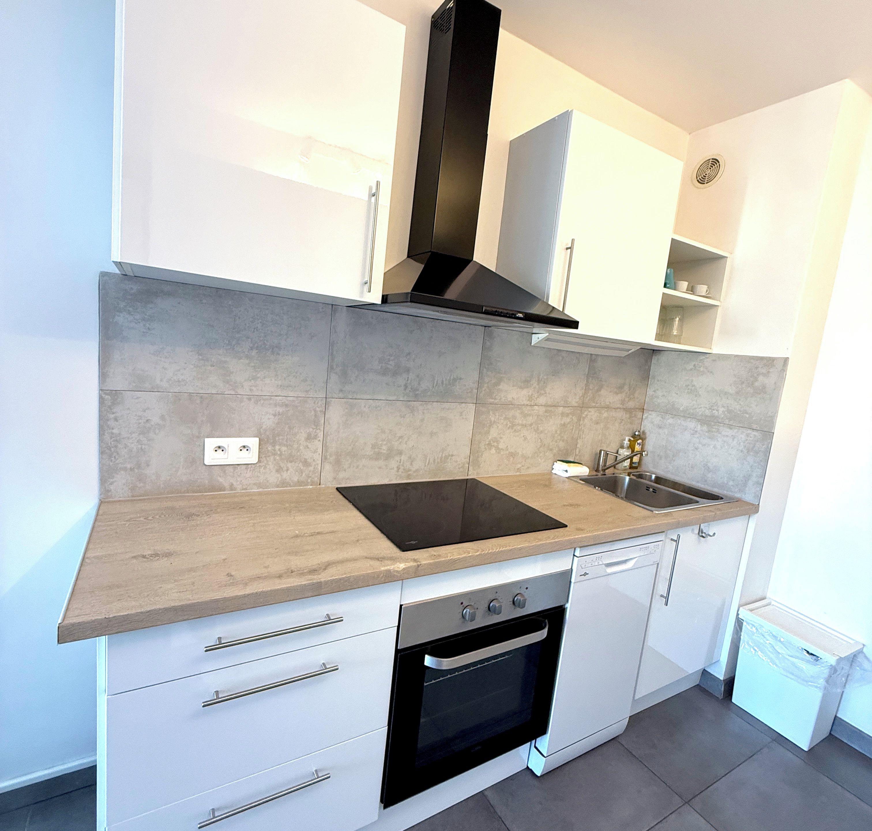 A modern kitchen with a built-in oven, a stovetop, and a dishwasher.