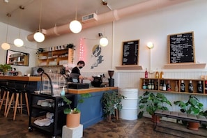 A cafe interior with a bar area, seating, and a menu board. - King & Queen Bed pet-friendly Downtown St Pete (St. Petersburg)