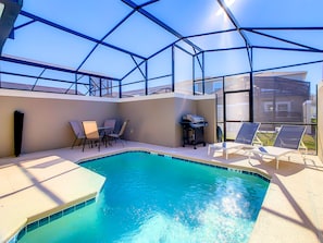 A swimming pool with a glass ceiling, surrounded by lounge chairs and a barbecue grill. - 5BRStorey Lake Resort | Private Pool | Near Disney (Kissimmee)