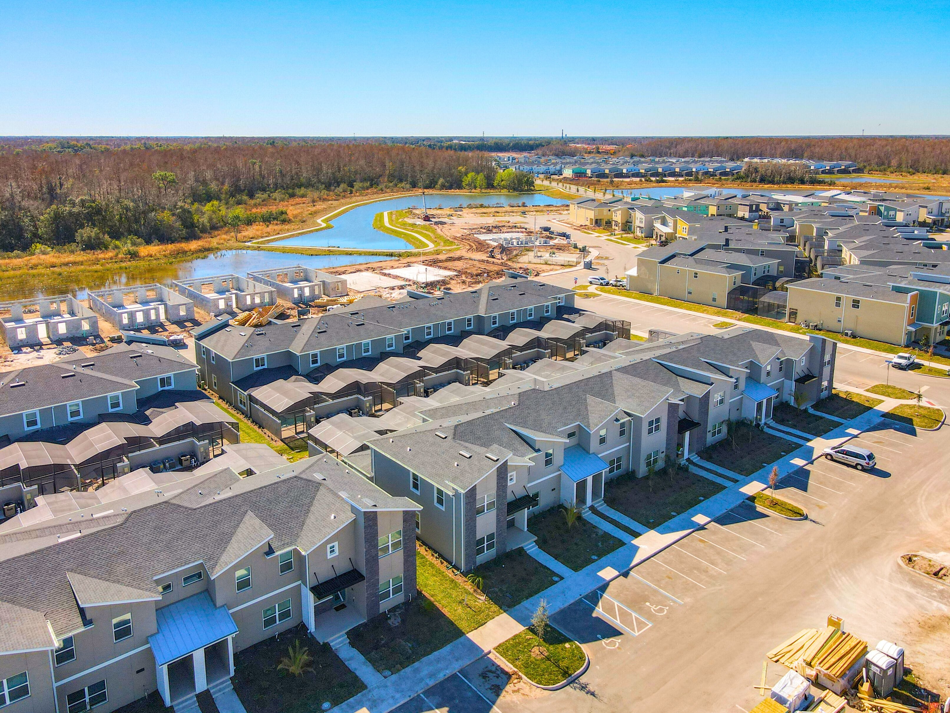A residential area with multiple apartment buildings, a parking lot, and a water body.