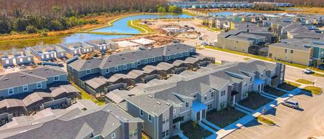 A residential area with multiple apartment buildings, a parking lot, and a water body.