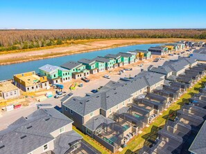 A residential area with multiple houses, a river, and a clear sky. - 5BRStorey Lake Resort | Private Pool | Near Disney (Kissimmee)
